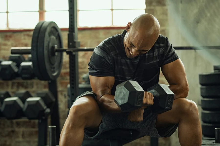 deportista musculando bíceps en gimnasio