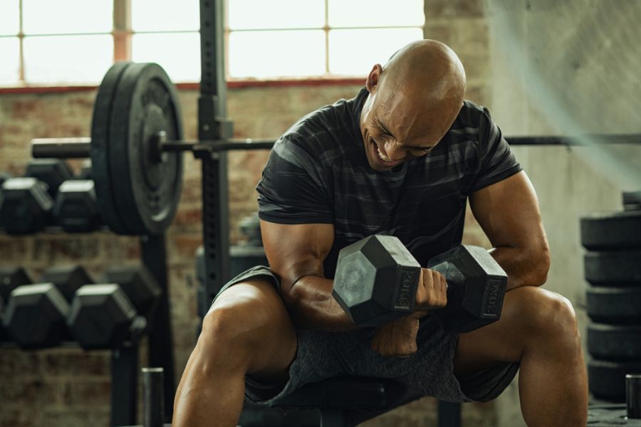 deportista musculando bíceps en gimnasio
